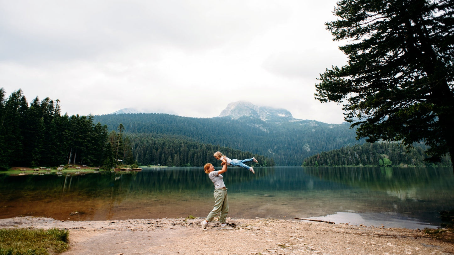 mom-and-toddler-daughter-have-fun-together-near-black-lake