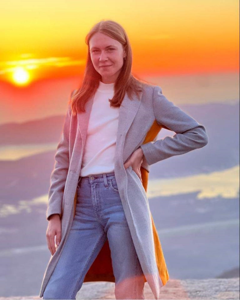 A person from Montenegro posing for a picture in front of the setting sun