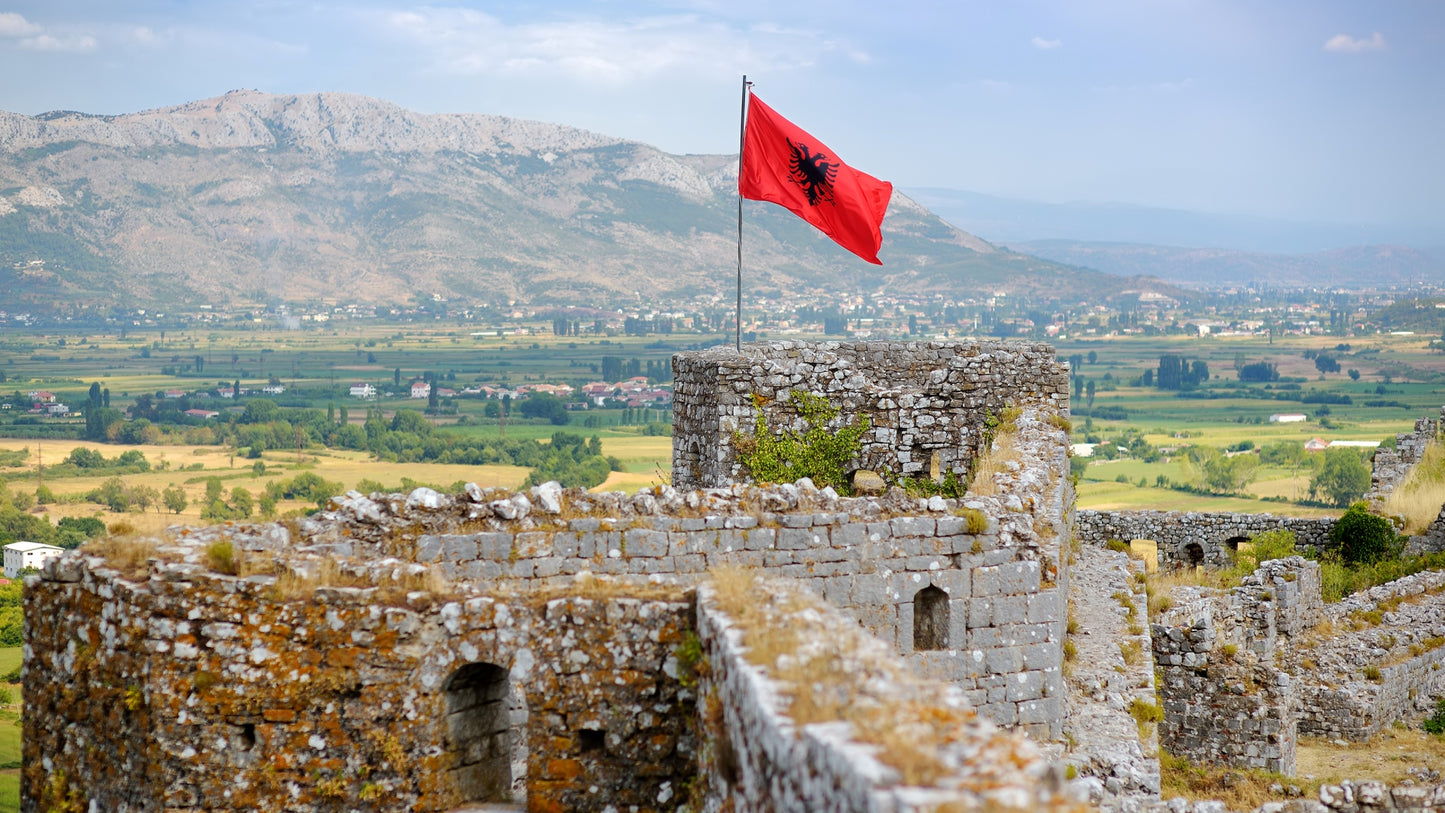 red albanian flag with black eagle waving over wall